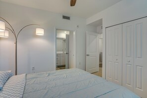 A bedroom with a bed, a wardrobe, and a bathroom visible through an open door. - Punta Gorda Resort Condo: Pool Access, Lanai (Punta Gorda)