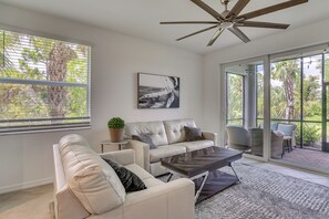 A modern living room with a leather sofa, a coffee table, and a ceiling fan. - Punta Gorda Resort Condo: Pool Access, Lanai (Punta Gorda)