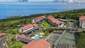 Ein Resort mit mehreren Gebäuden, einem Schwimmbad, Tennisplätzen und Solaranlagen.