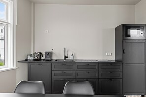 A compact kitchen with a microwave, sink, and cabinets. - Best View in Downtown Reykjavik!  3 Bedrooms + 3 Ensuite-Bathrooms (Reykjavík)
