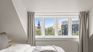 Ein Schlafzimmer mit einem großen Fenster, einem Bett und einer Heizung.