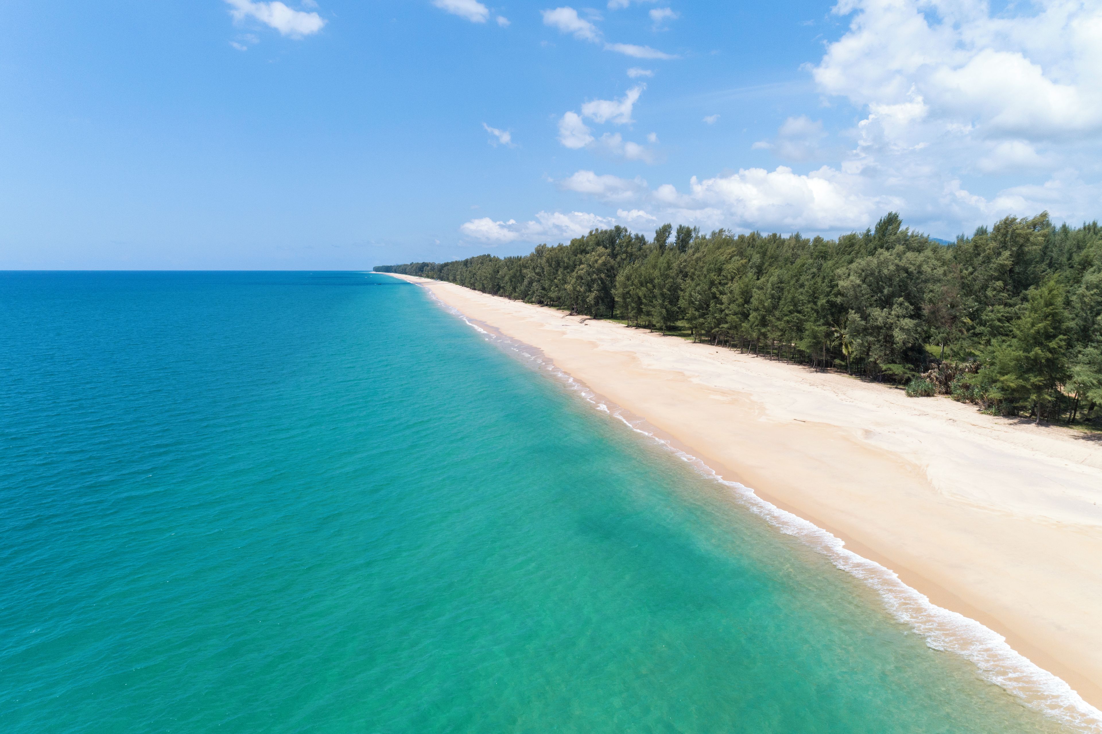 A beach with clear turquoise water and a sandy shore.