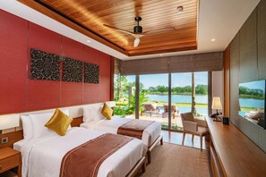 A hotel room with two beds, a large window with a view of a lake, and a ceiling fan. - Aquella Lakeside Villas (Thai Mueang)