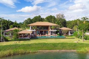 A large house with a swimming pool, surrounded by lush greenery and a pond. - Aquella Lakeside Villas (Thai Mueang)