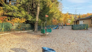 A playground with a slide, climbing structures, and a fenced area.