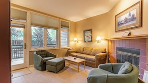 A cozy living room with a fireplace, a sofa, a chair, and a coffee table.