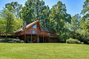A large wooden cabin with a prominent chimney, large windows, and a covered porch area. - Pinnacle Lakefront Retreat: Dock, Canoe & Fire Pit (Pinnacle)