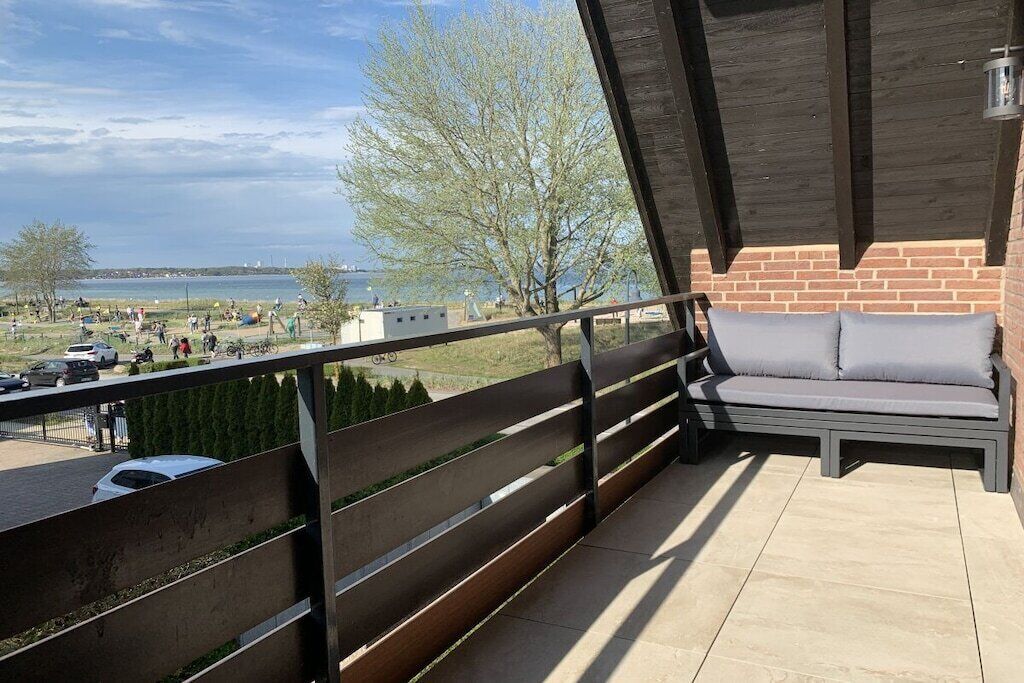 Un balcon donnant sur une plage et un mur en briques.