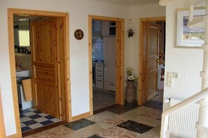 Ein Flur mit Holztüren zu einer Küche und einem Badezimmer.