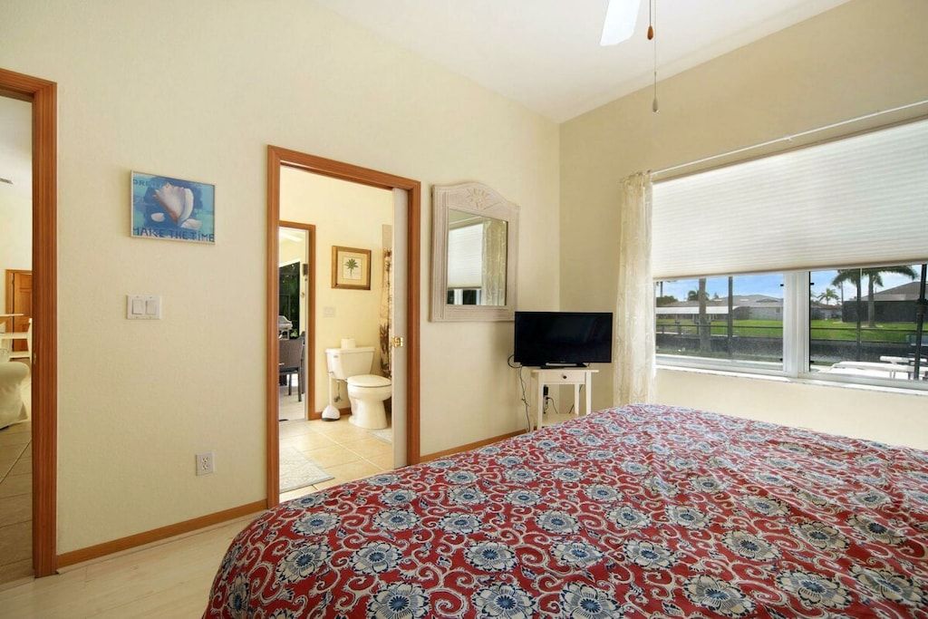 Una camera da letto con un letto, una televisione, una finestra vista e una porta che conduce al bagno.