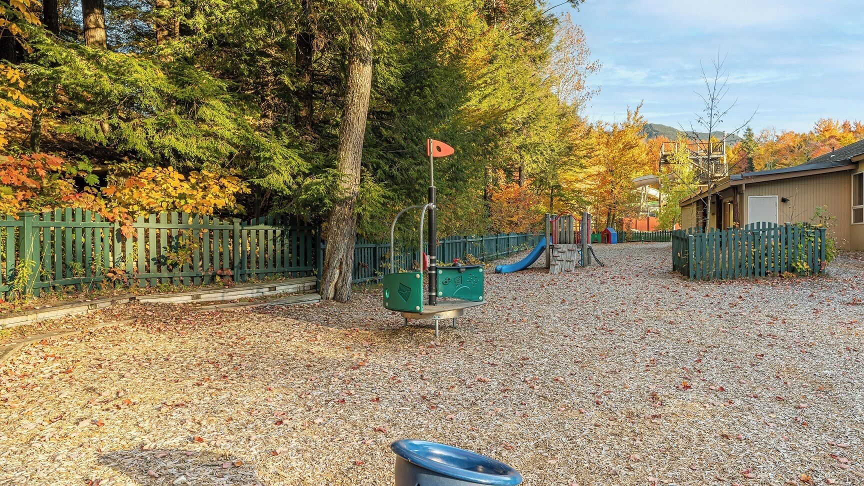 A playground with a slide, climbing structures, and a fenced area.