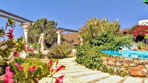 A garden with a statue, a pool, and a pergola. - Holiday Apartment for 3 People (59 m²) in La Sabinita with Sea View (La Sabinita)