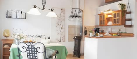 A dining area with a green table, chairs, and a chandelier.