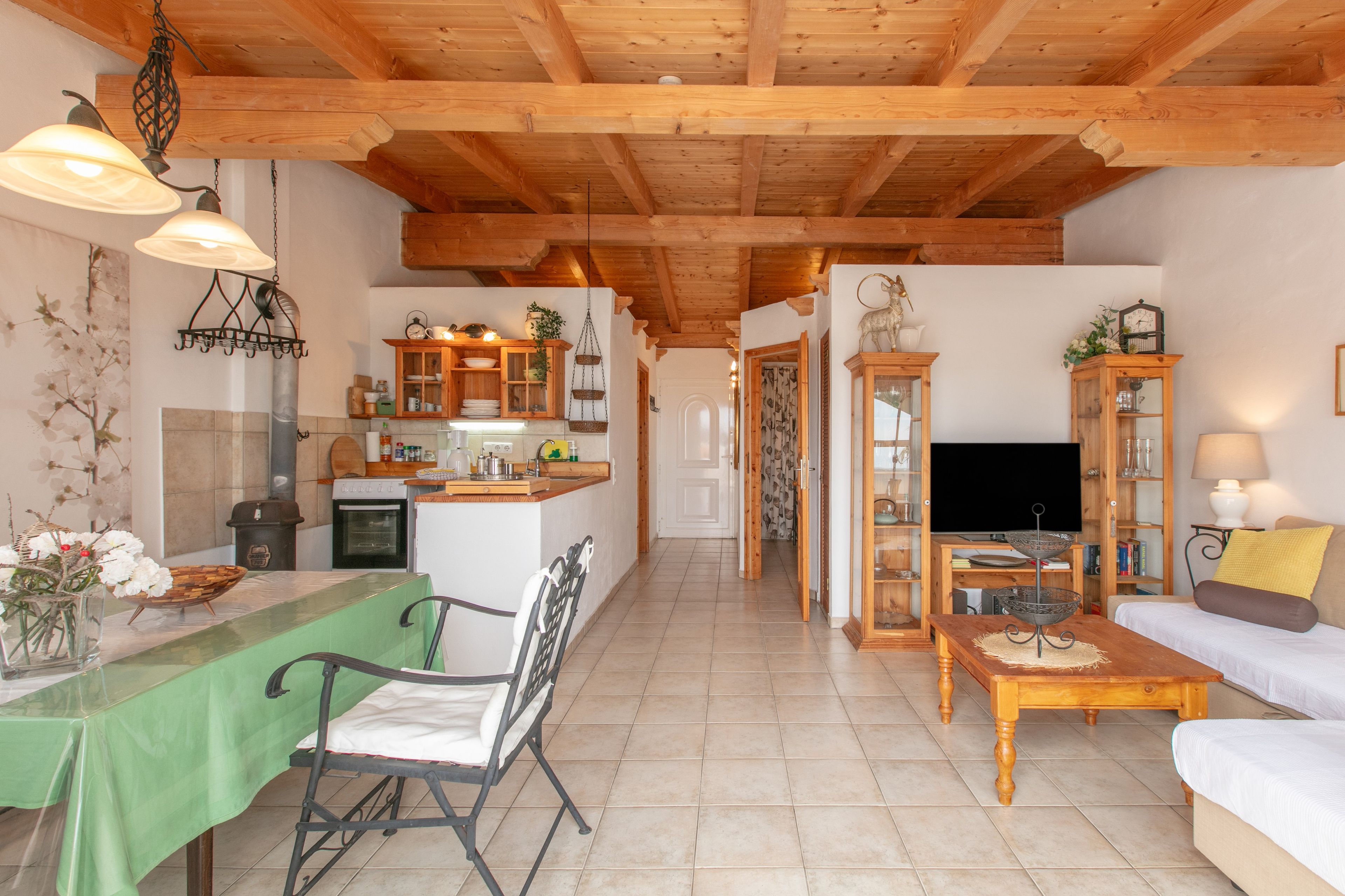 A spacious living area with a dining table, a sofa, and a television.