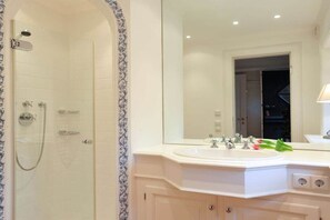 Ein Badezimmer mit Dusche, Waschbecken und Spiegel.