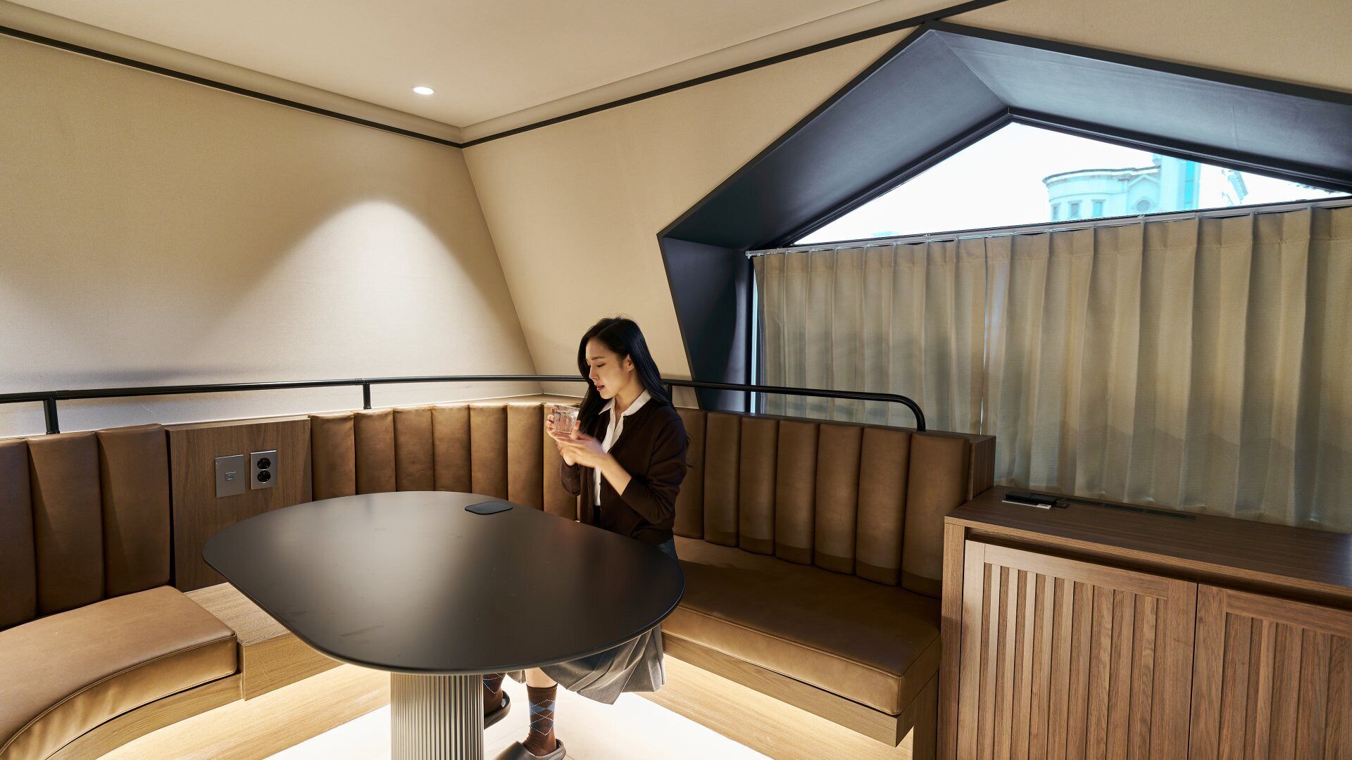 Un intérieur moderne avec une table ronde, des sièges rembourrés et une vue par la fenêtre.
