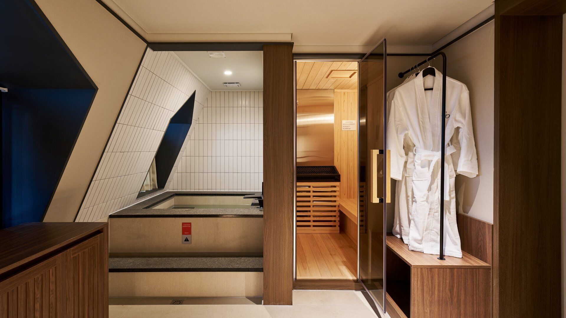 Une salle de bain moderne avec une douche à parois de verre, un plancher en bois et un porte-peignoir.