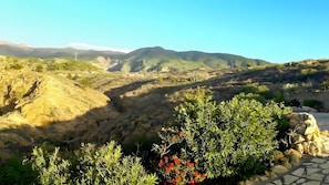 A natural landscape with a valley, hills, and a stone pathway. - Casa Rosa – Charming Two-Bedroom Apartment with Panoramic Views (La Sabinita)