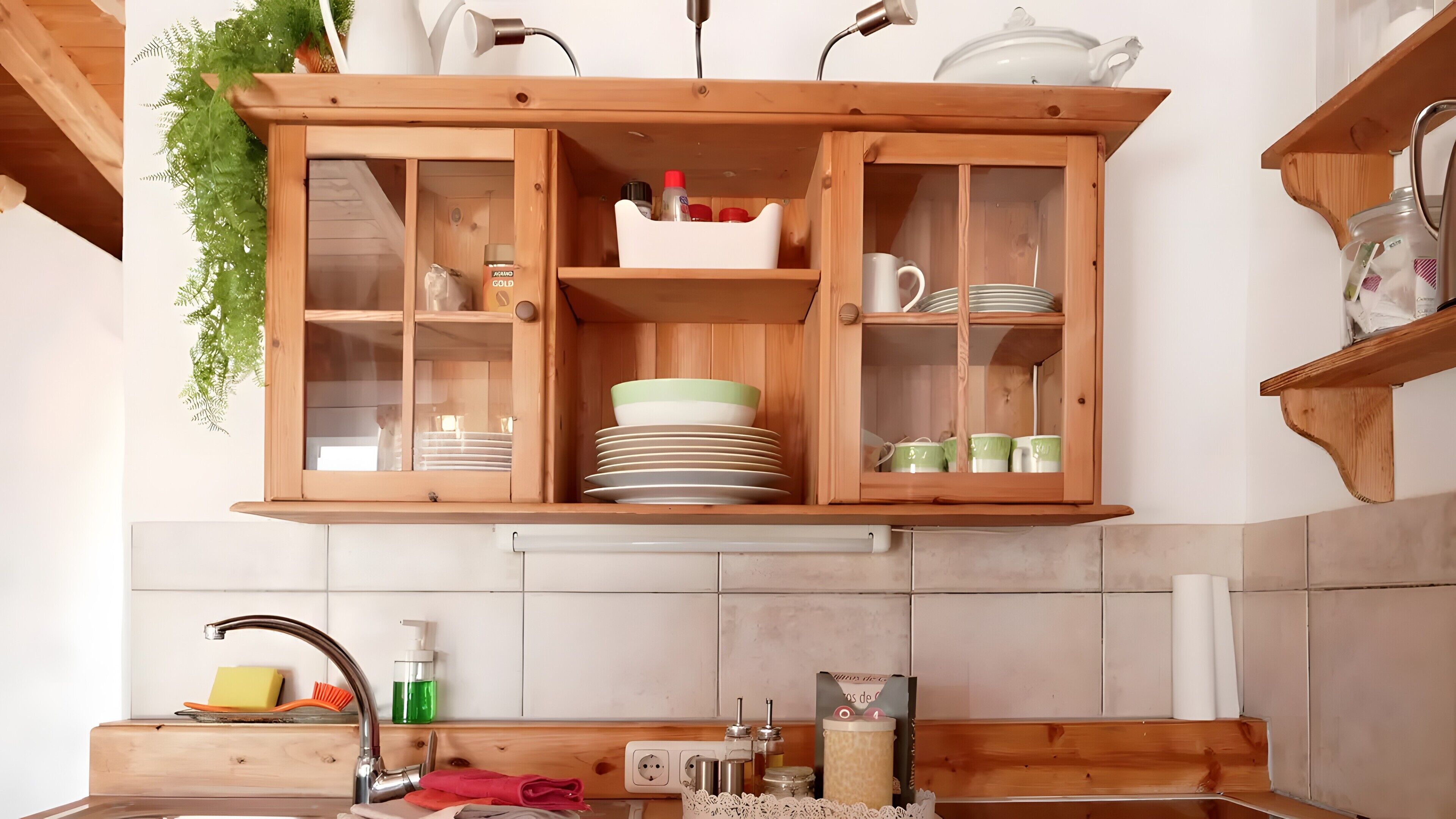 Una cocina con armarios de madera, un fregadero y varios utensilios de cocina.