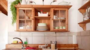 A kitchen with wooden cabinets, a sink, and various kitchen items. - Casa Rosa – Charming Two-Bedroom Apartment with Panoramic Views (La Sabinita)