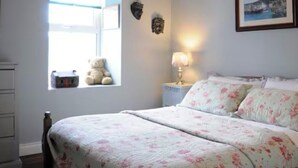 A bedroom with a bed, a window, a nightstand, a lamp, and a teddy bear. - Charming cottage on Mount Brandon,stunning unimpeded ocean views close to Dingle (Dingle)
