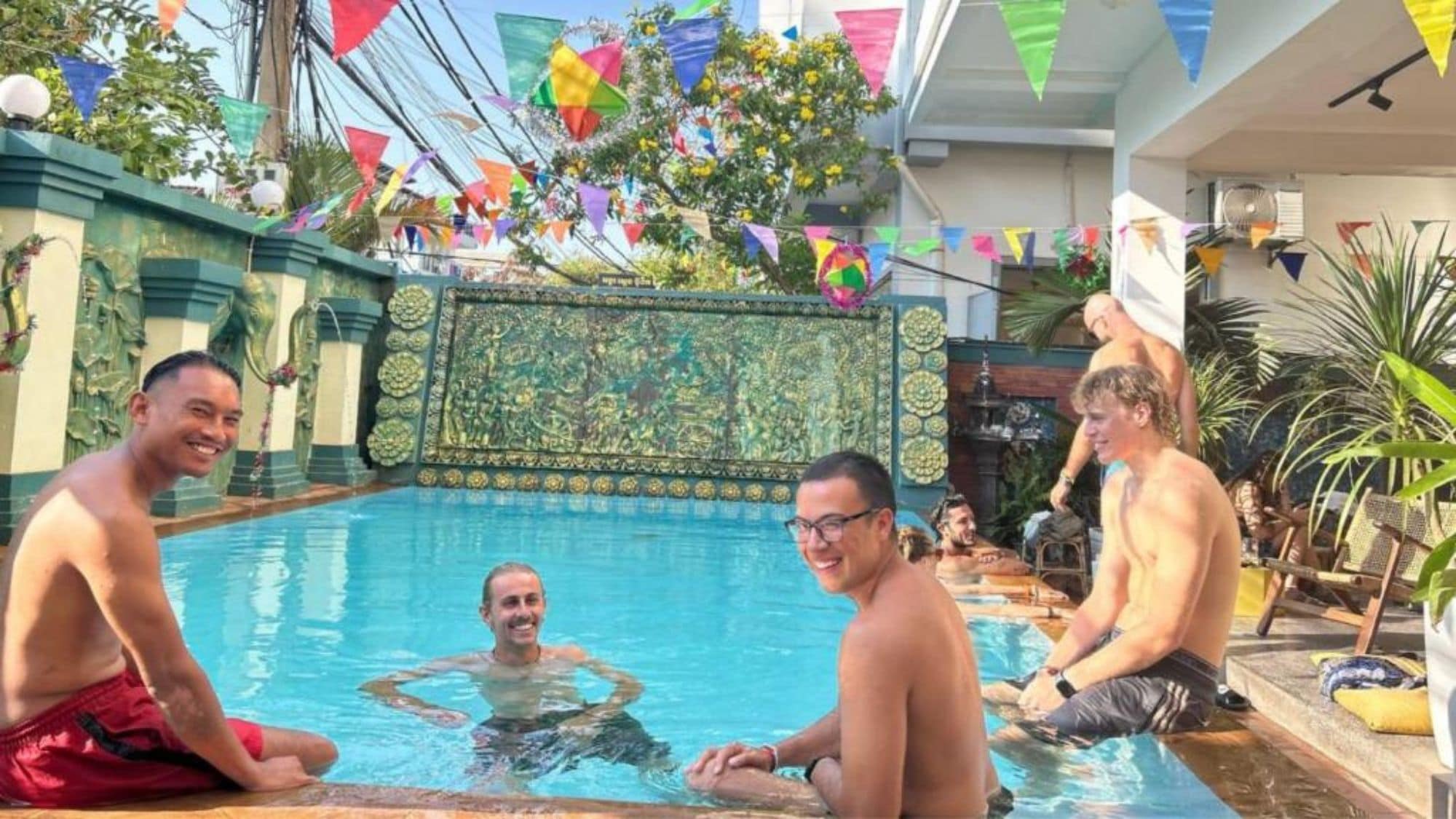 A swimming pool area with decorative tiles and flags.