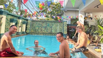 A swimming pool area with decorative tiles and flags.