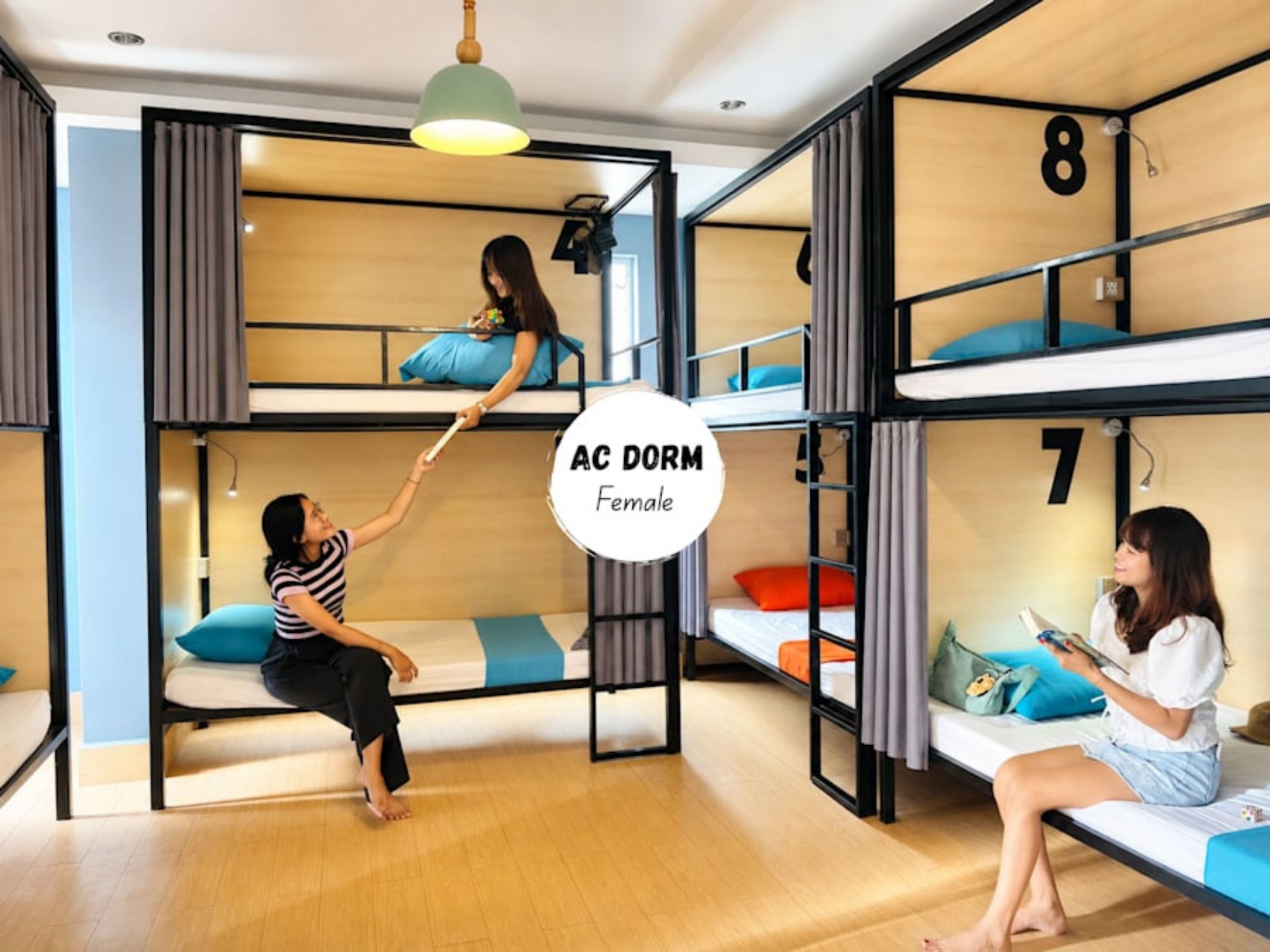 A dormitory room with bunk beds, a desk, and a chair.