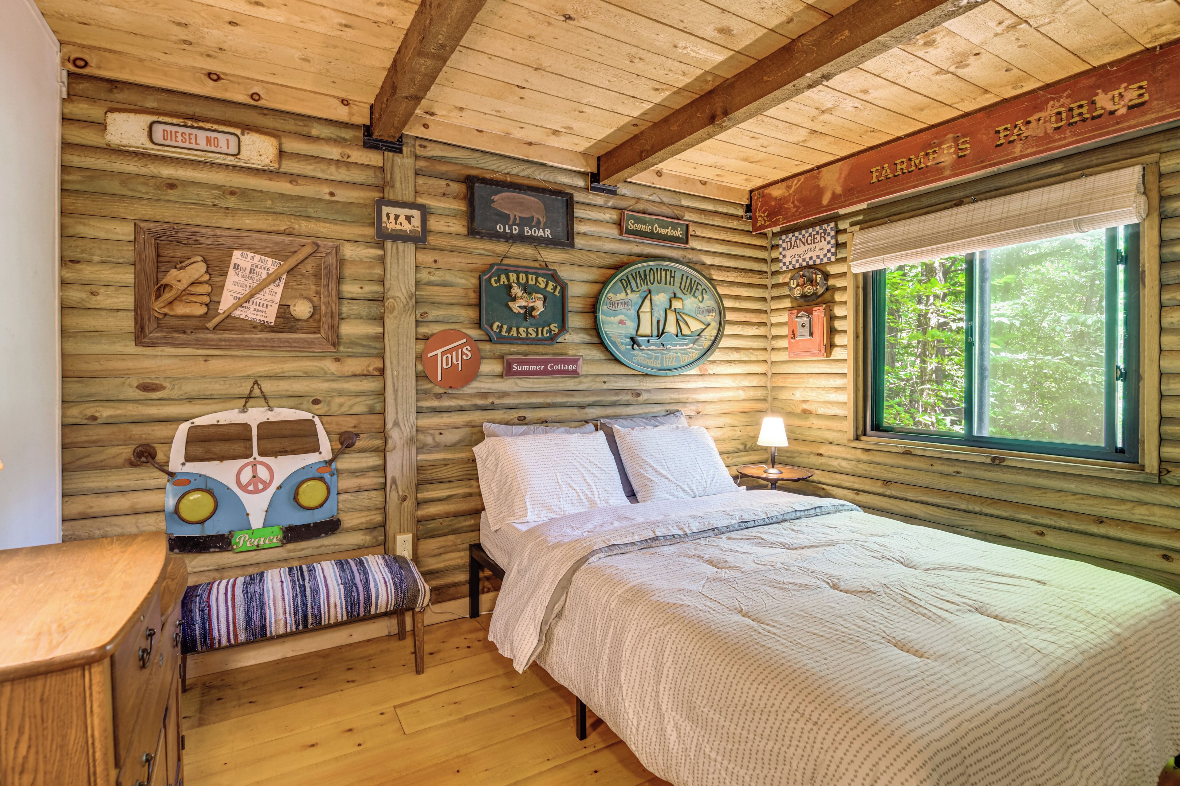 A cozy cabin-style room with a bed, a bench, and various decorative items on the walls.