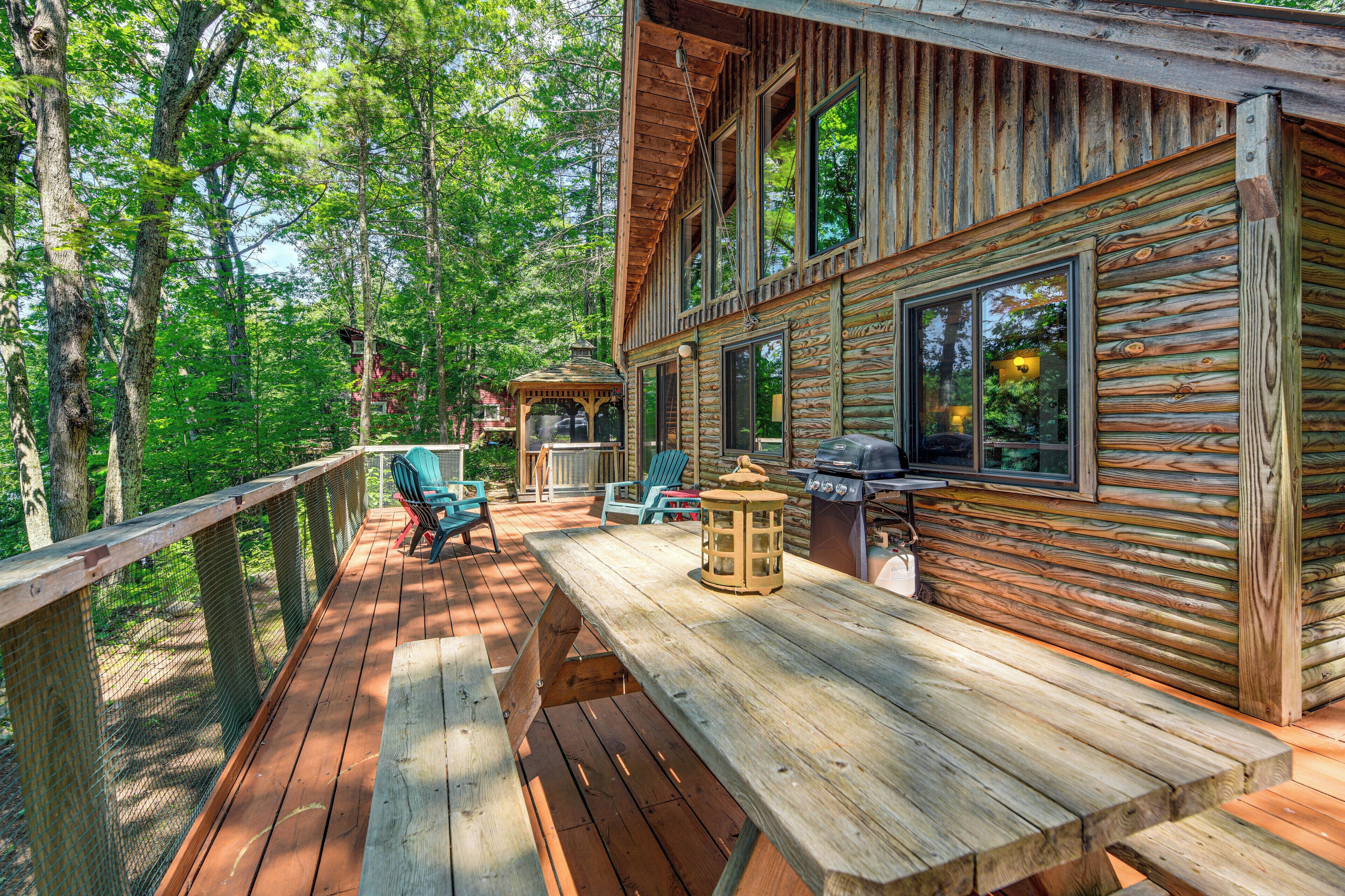 A wooden deck with outdoor seating and a barbecue area.