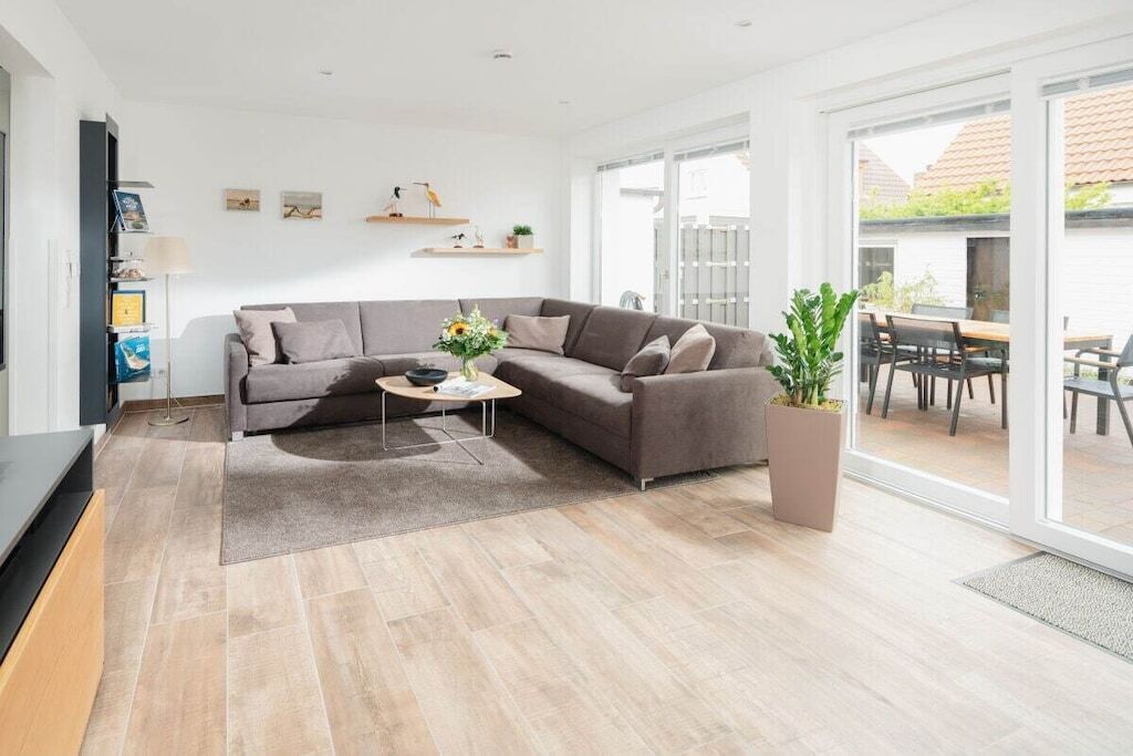 A modern living room with a sectional sofa, a coffee table, and a potted plant.