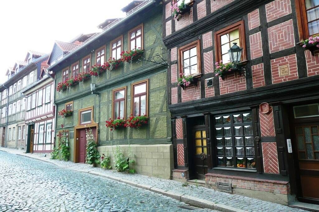 A traditional European building with a cobblestone street, wooden shutters, and flower boxes on the windows.
