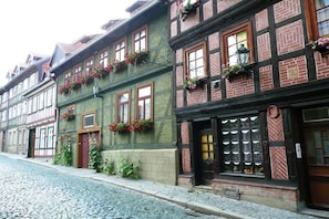 A traditional European building with a cobblestone street, wooden shutters, and flower boxes on the windows. - Holiday apartment Assenta (Blankenburg)