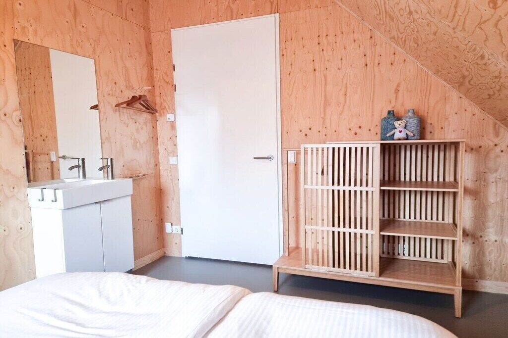 Une chambre à coucher avec un lit, une armoire blanche, une étagère en bois et un miroir.