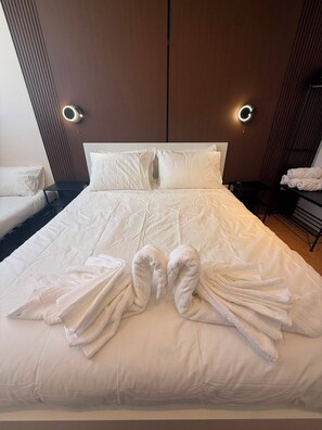 A neatly made bed with white linens and two towels folded on the bed. - Prestigious Suite Near Mamilla—View of the Ancient Walls (Jerusalem)