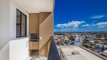 Un balcó amb vista a una zona residencial i muntanyes llunyanes.