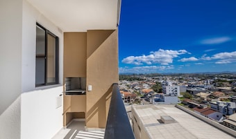 Un balcón con vista a una zona residencial y montañas distantes.