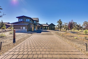A two-story house with a paved driveway leading to the entrance. - Golf Views, Resort Pool Access! Brasada Ranch Home (Powell Butte)
