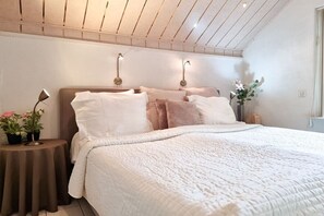 Ein Schlafzimmer mit einem Bett, Nachttischen und Wandleuchten.