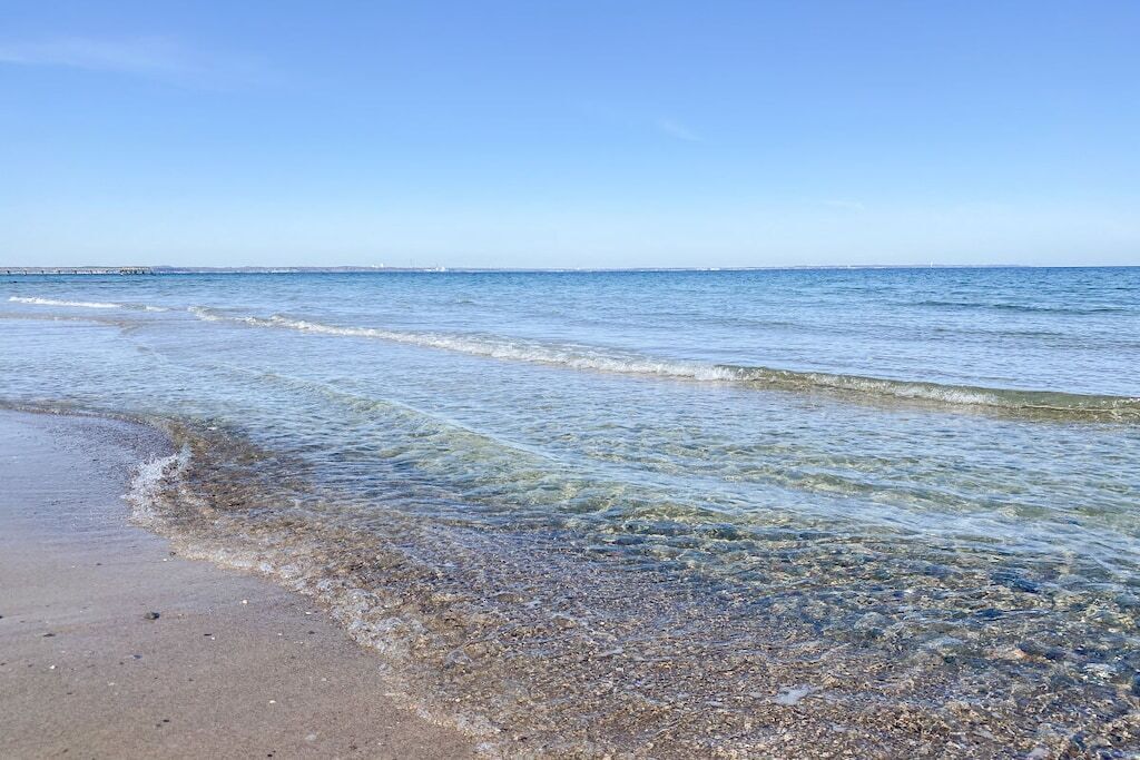 A beach with clear water and a visible shoreline.