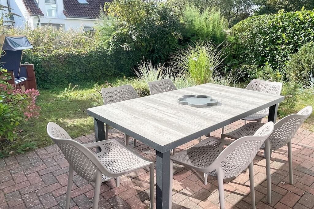 An outdoor patio with a rectangular table and six chairs.