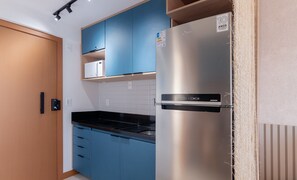 A kitchen with blue cabinets, a stainless steel refrigerator, and a microwave on a shelf. - Studio w/ Pool 500m From the Beach Znb1406 (Salvador)