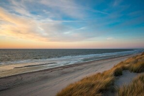 Une plage avec un ciel dégagé et des vagues douces.