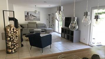 A modern living room with a sofa, a coffee table, and a TV stand.