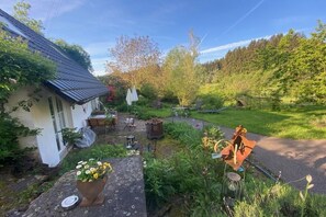 A house with a garden, outdoor furniture, and a rustic outdoor seating area. - Organic farm with 2 bedrooms (Elzach\/Heidburg)