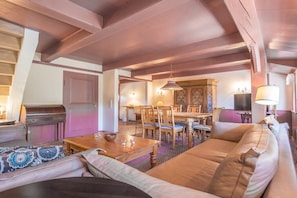 Un salon chaleureux avec un canapé, une table basse en bois et un coin repas comprenant des chaises et une table.