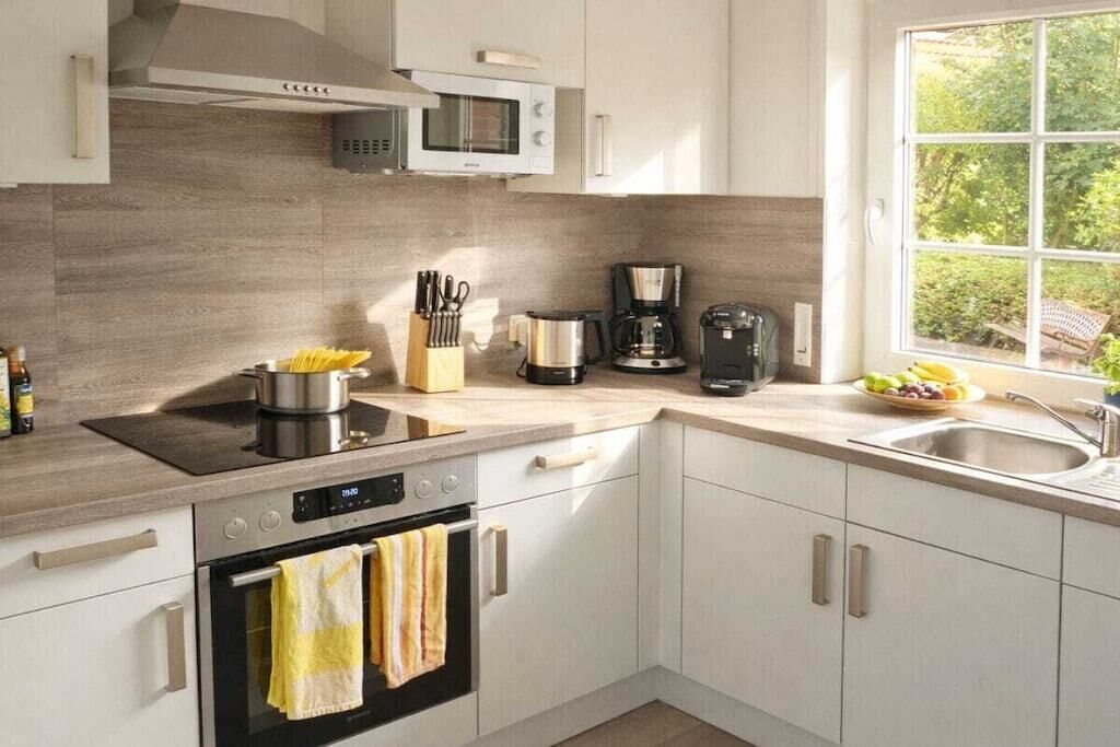 A modern kitchen with a microwave, coffee maker, and oven.