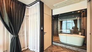 A modern bathroom with a large mirror, a white sink, and a wooden floor. - Luxury 3BR Loft with Private Pool & City Views in Makati (Makati City)