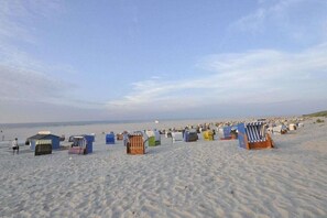 A beach with numerous beach huts and a clear sky. - Holiday apartment in Juist with swimming pool (Juist)