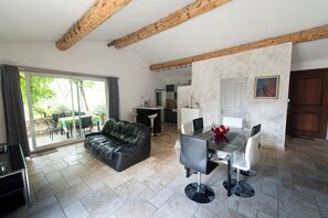A modern living space with a dining area, a sofa, and a kitchen. - Just a short walk from the Luberon Mountains—accommodations for up to six people (Maubec)